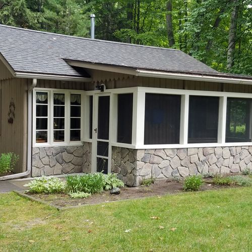 Overall:  the front of the cabin, highlighting the screened-in front porch