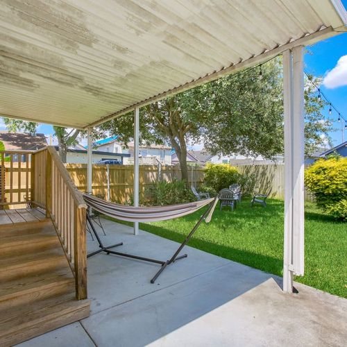 Unwind in the shade on this covered patio, complete with a hammock for ultimate relaxation. The spacious backyard offers plenty of room for outdoor activities or simply enjoying the peaceful surroundings. Perfect for a morning coffee or an evening breeze.