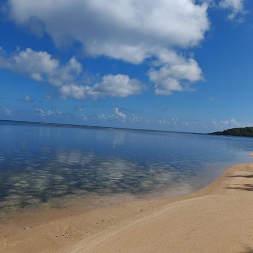 Escape to the serene beauty of the Malolos coast! This calm, clear water and sandy shore invite you to relax under a beautiful blue sky with soft, wispy clouds.