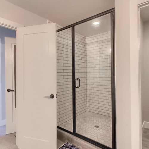 - step into this sleek walk in shower with glass doors and classic white subway tile