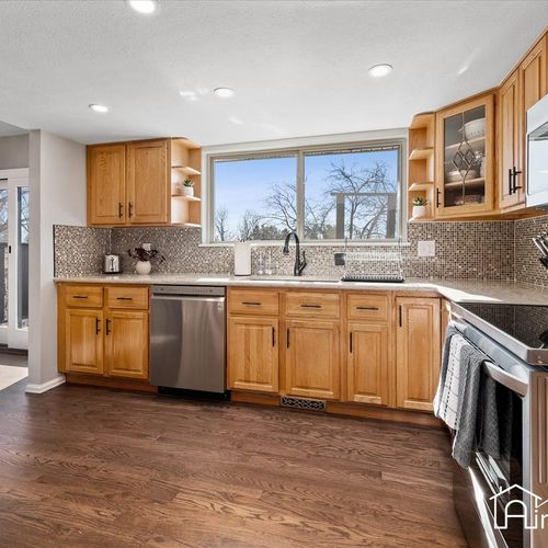- enjoy garden views while prepping meals at the large window above the sink area
- natural light fills this bright kitchen with stainless appliances & wooden cabinetry
- backsplash tiles add visual texture while countertops offer extra of prep space