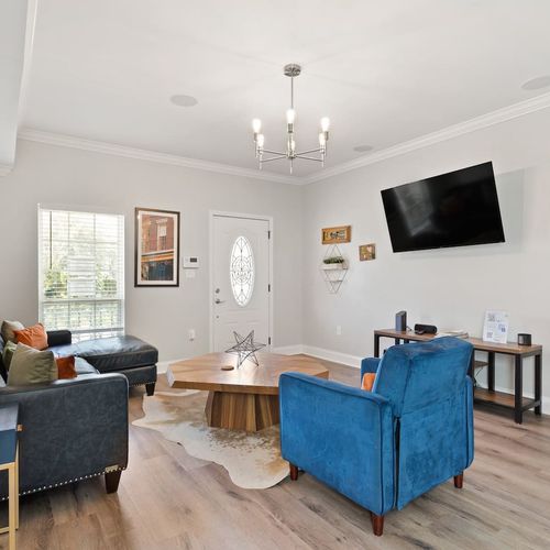 New Orleans-inspired living room w/ bold blue accents & TV for all your streaming needs.