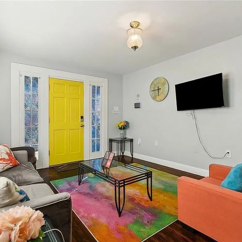 Welcome to your vibrant NOLA retreat! Relax in this stylish living space, filled with bold colors and cozy seating—perfect for unwinding after a day of exploring the Big Easy!"