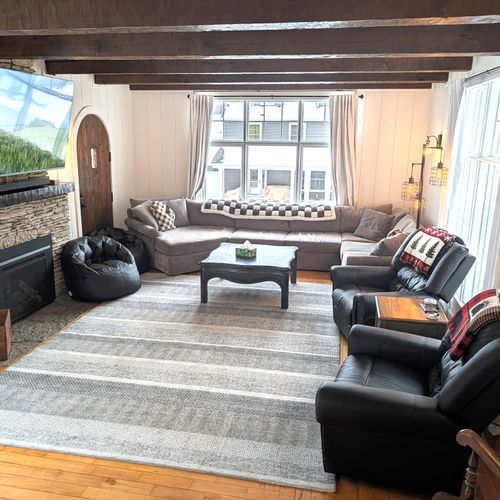 OVERVIEW:  The gorgeous main floor living room featuring a very large television with live streaming, tons of seating, and a beautiful natural gas fireplace.