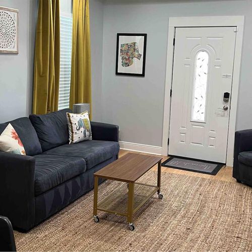 Bright, airy living room w/ comfy sofa & warm natural light pouring in.