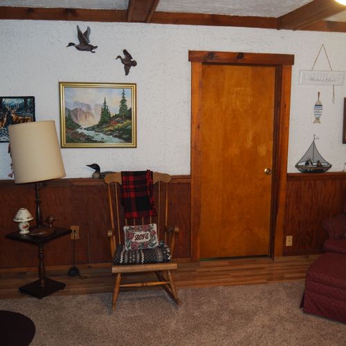 Living room:  includes a sofa, comfy chairs, live-streaming television, and entrance out to the deck.