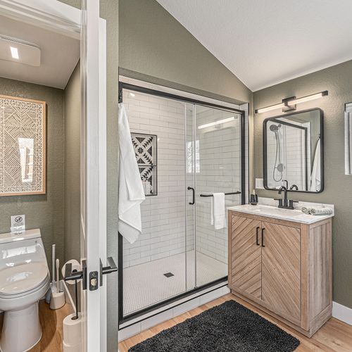 The primary ensuite features an integrated bathroom with a spa-inspired walk-in shower, modern vanity, and separate water closet.