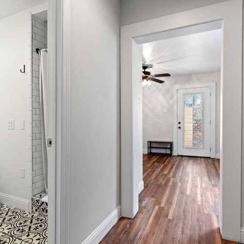 Bright hallway leading to a full bathroom — clean & easy to navigate.