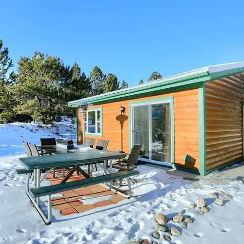 The exterior of our moose cabin with patio seating just outside your door.