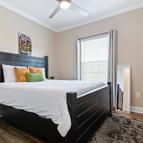 Cozy queen bedroom w/ warm tones & soft bedding for a restful night's sleep.