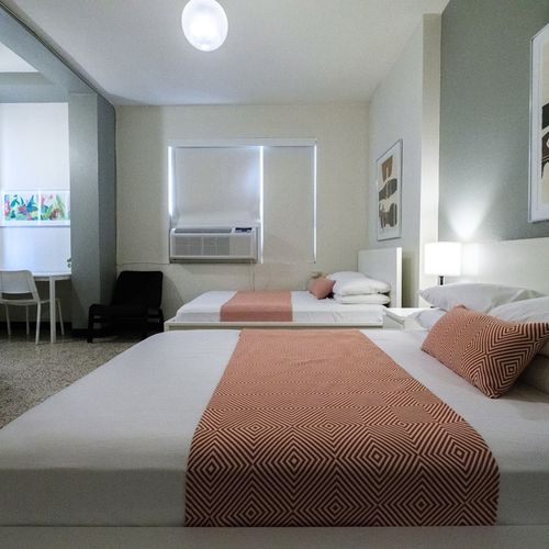 Experience a blend of modern aesthetics and cozy comfort in this inviting bedroom, complete with a comfortable bed and artistic touches that make it feel like home.