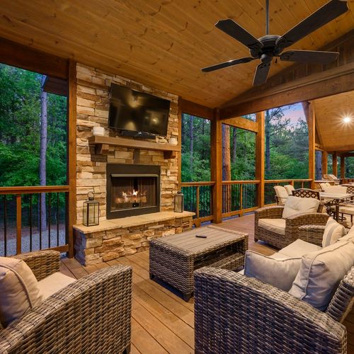 Covered patio has outdoor seating around the fireplace and tv!
