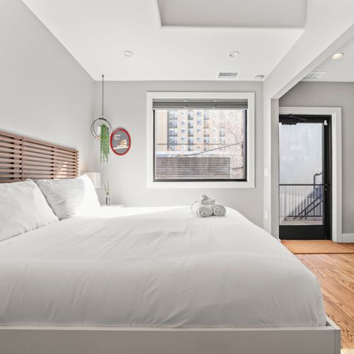Primary bedroom with blackout curtains and sliding door.