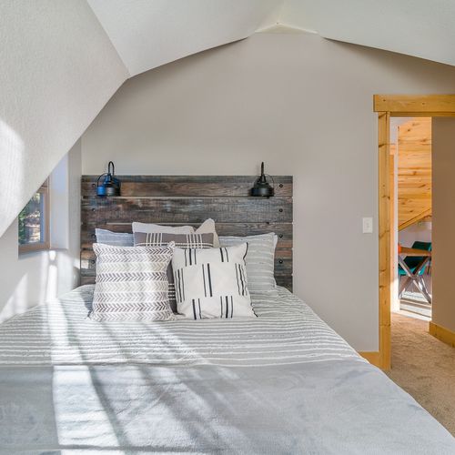 The 2nd bedroom off the loft area features a queen bed, delicate linens and blackout curtains.