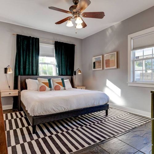 Restful master bedroom w/ a plush bed & bold striped rug to set the mood.