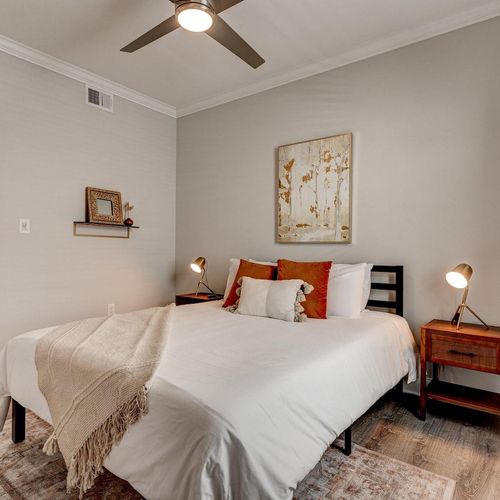 Cozy bedroom w/ warm tones & soft bedding for a good night's rest.