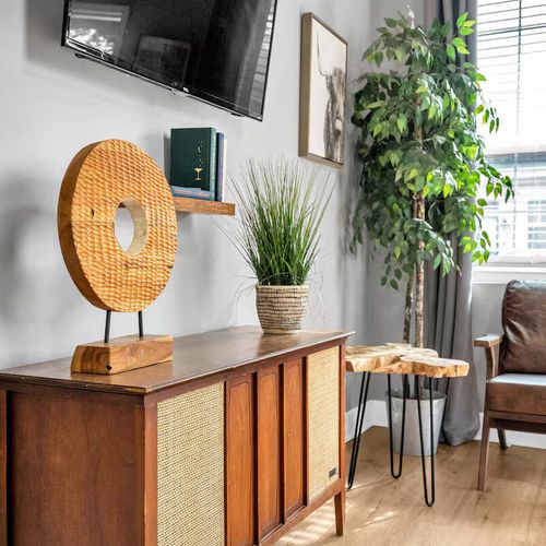 Rattan mirror & lush greenery bring a warm, natural touch to the décor.