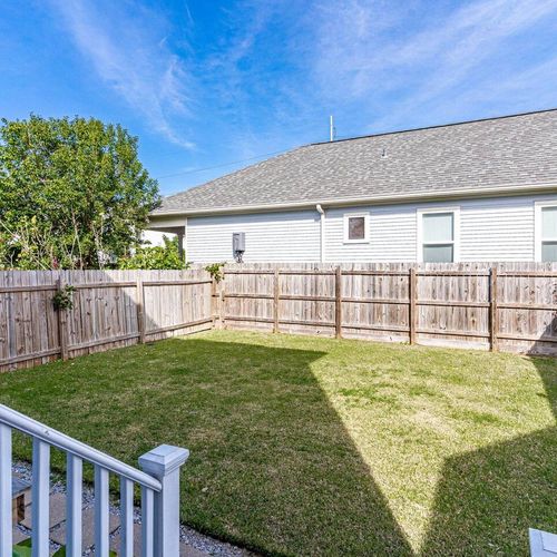 Spacious backyard w/ a lush green lawn — room to breathe & play.