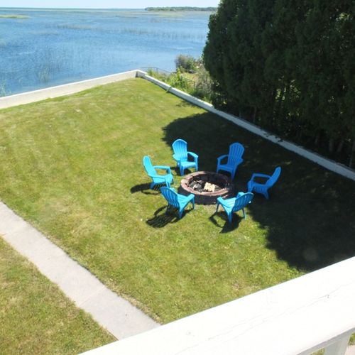 Exterior:  looking down from the upstairs balcony at the fire ring and chairs.