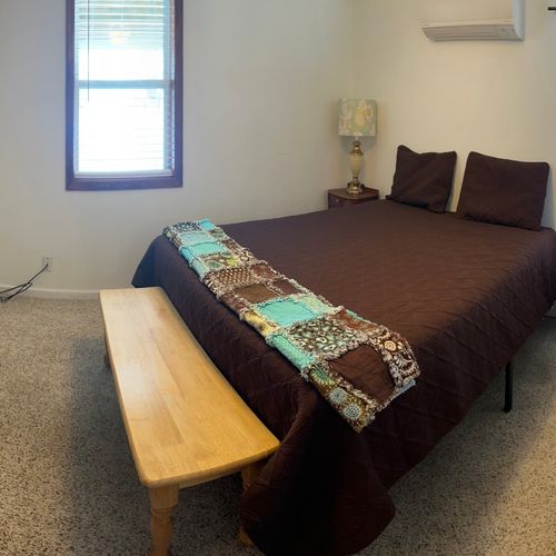Bedroom #1 (main floor):  features a queen-size bed, bunk bed, ceiling fan, heating and cooling unit, night stands, lamps, dresser, and mirror.