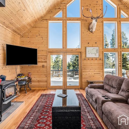 - soaring ceilings and floor to ceiling windows flood the space with light and views
- relax by the wood burning stove or enjoy a movie night on the mounted flat screen
- rustic charm and mountain ambiance make this the heart of your cabin retreat