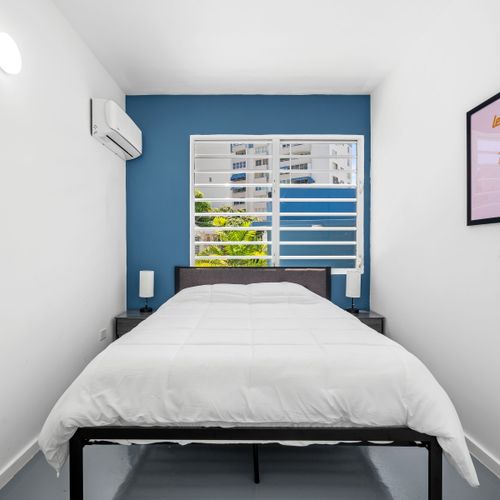 Relax in a stylish, modern room with a striking blue accent wall, cozy white rocking chairs with orange pillows, and a flat-screen TV for your entertainment.