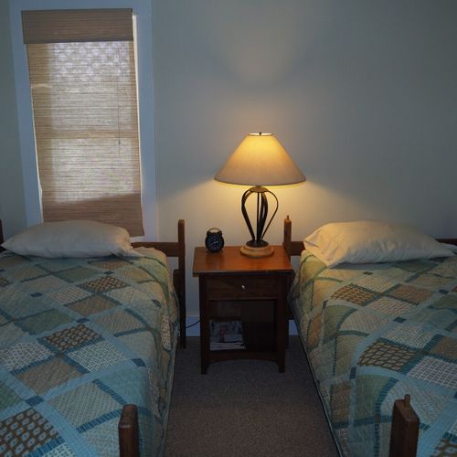 Bedroom #2:  features two twin beds, a nightstand, lamp, dresser, mirror, and closet.