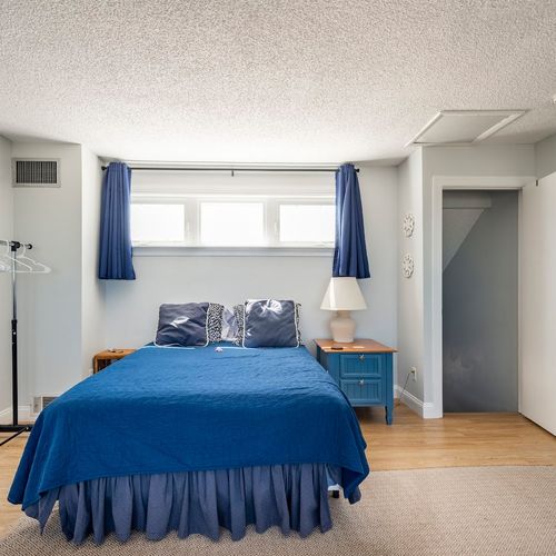 This shared bedroom provides an inviting and refreshing space, boasting an abundance of natural light.