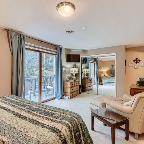The master bedroom provides a plush leather armchair complete with an ottoman, and several dressers for storage.