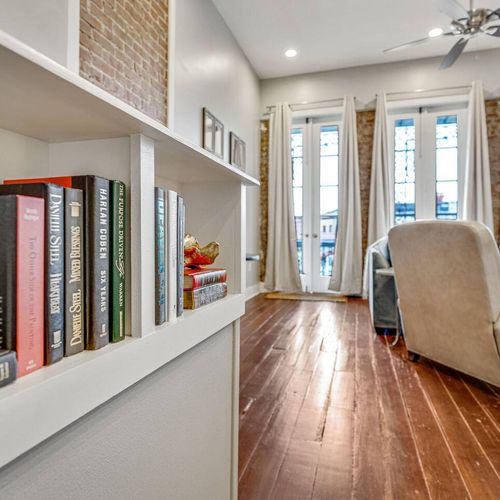 Charming hallway w/ warm wood floors & natural light leading through the space.