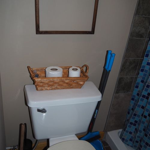 Bathroom:  features a shower and a toilet. (note that there is no vanity, sink, or mirror in the bathroom. )