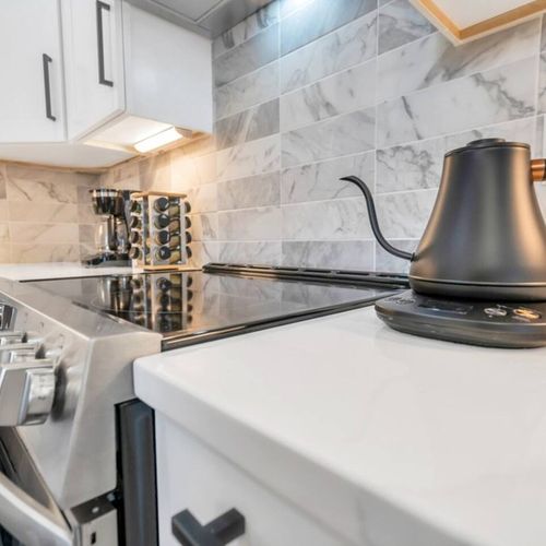 Luxe kitchen counter w/ marble finishes & a statement range hood.