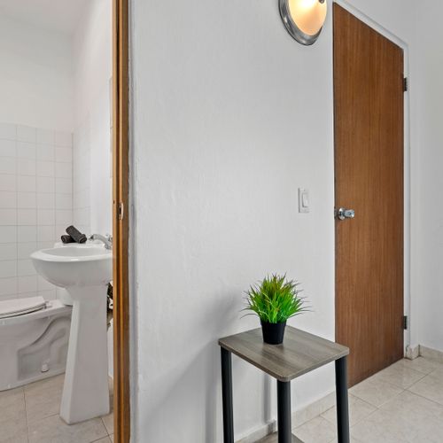Indulge in comfort in a brightly lit bathroom furnished with modern fixtures and a generously sized shower area.