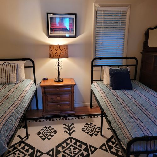 BEDROOM #3 (FIRST FLOOR):  Features two twin beds, a nightstand, lamp, dresser, and closet