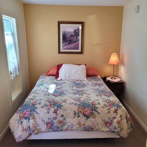 BEDROOM #1:  Features a queen-size bed, dresser, closet, and chair.