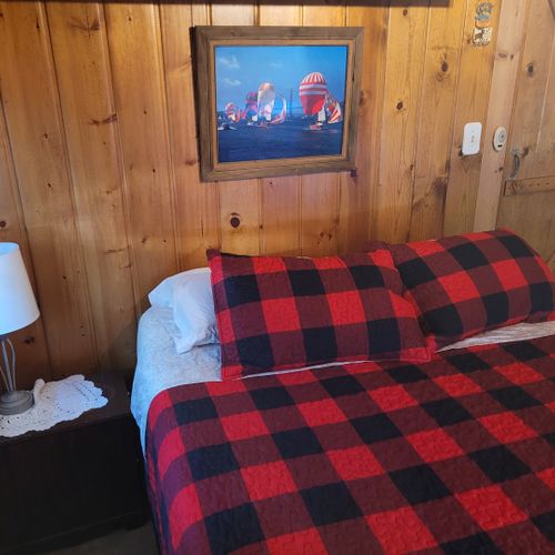 Bedroom #1:  features a queen-size bed, nightstand, lamp, mirror, dresser, and clothes rack.