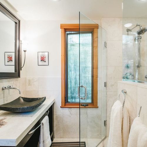 Custom-tiled, walk-in shower and granite vanity