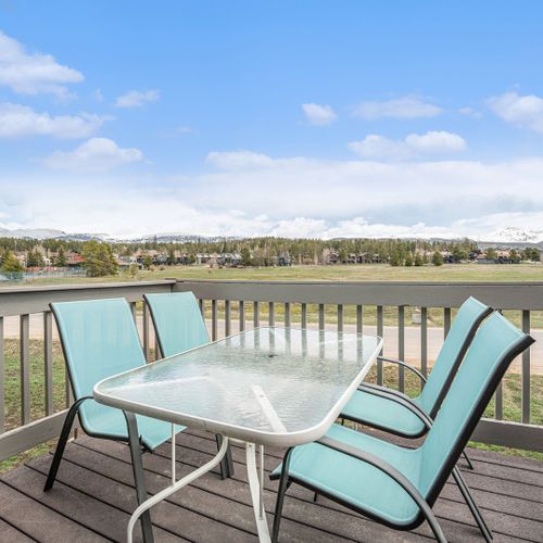 Relax on the balcony with seating, enjoying panoramic mountain and skyline views.