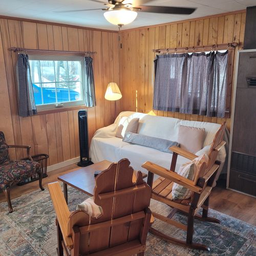 Living room #1:  the home has a cozy living room in the center of the cabin with a sofa, 3 chairs, and a coffee  table.