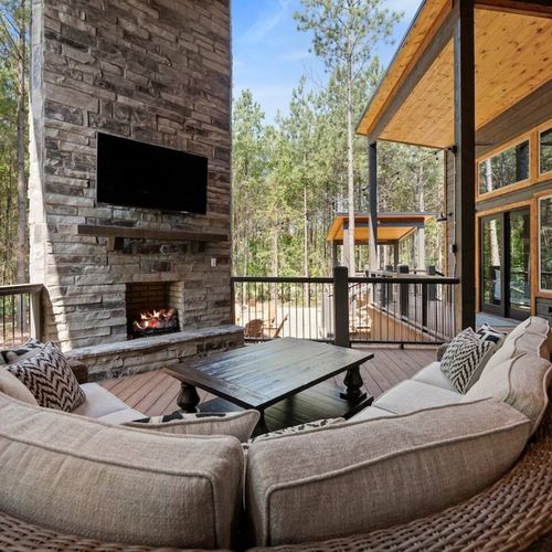 The outdoor patio has an oversized sofa around the fireplace