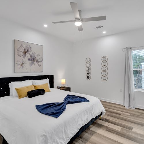 Unwind in a spacious bedroom featuring a plush bed with elegant decor, warm lighting, and a touch of New Orleans charm—perfect for a restful night's sleep.