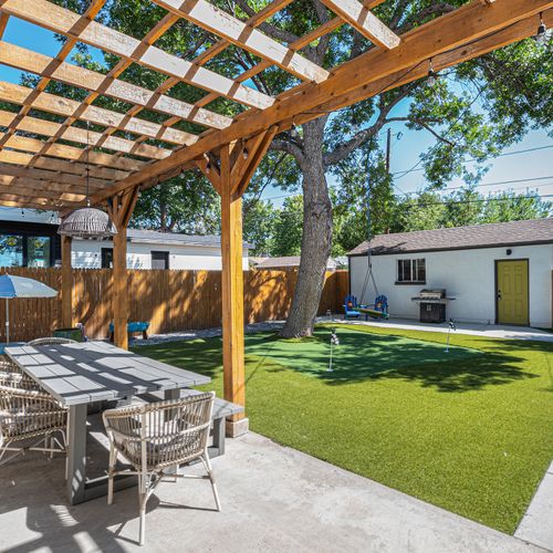 Enjoy outdoor dining under the pergola in the spacious backyard.