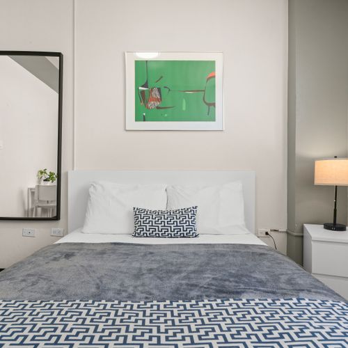 Experience ultimate comfort in our well-lit bedroom, complete with modern furnishings, blackout blinds for undisturbed sleep, and a refreshing air conditioning unit to keep you cool.