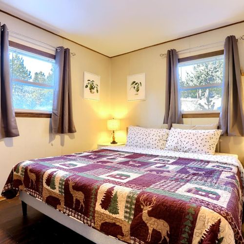 - snuggle up in a spacious bed with woodland themed bedding and soft lighting
- large windows bring in natural light and views of the surrounding pines
- minimalist wall art and nightstands create a peaceful, inviting sleep space- snuggle up in a spa