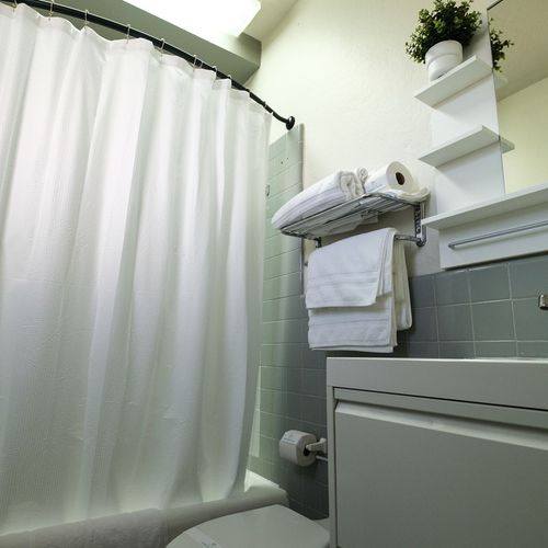 Our clean and well-maintained bathroom offers all the necessities, including a spacious shower area with easy access to fresh towels for your convenience.