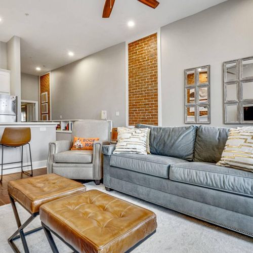 Sink into the plush sofa in this warm, brick-walled living room made for relaxing.
