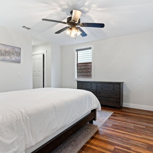 Bright queen bedroom w/ a ceiling fan & natural light for cool, easy nights.