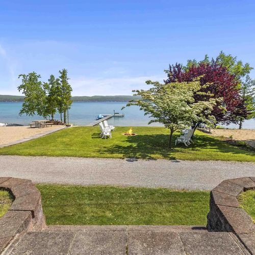 EXTERIOR:   Looking out from the back porch at the private bonfire ring, beach, lakefront, and dock