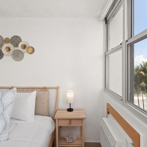 room with beachfront beach views, bed and wall art