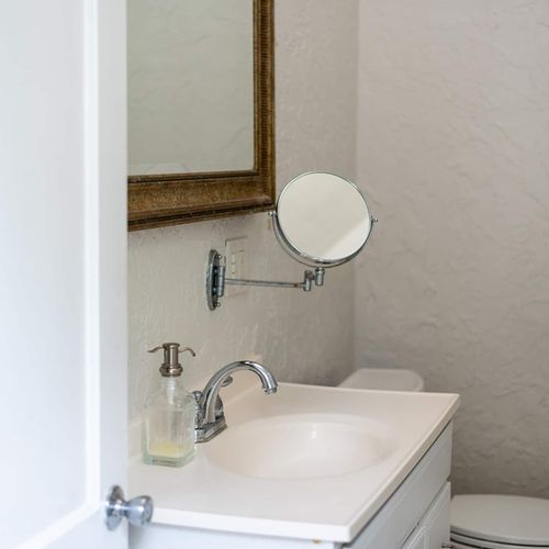 Bright and clean bathroom with a classic touch. Equipped with essential amenities and a vanity mirror, it’s the perfect spot to freshen up in style during your stay.